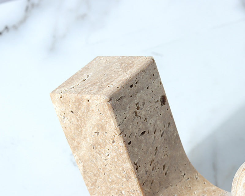 Close-up of a textured stone sculpture against a blurred natural background