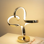 Gold spiral table lamp on a white surface with a soft beige background