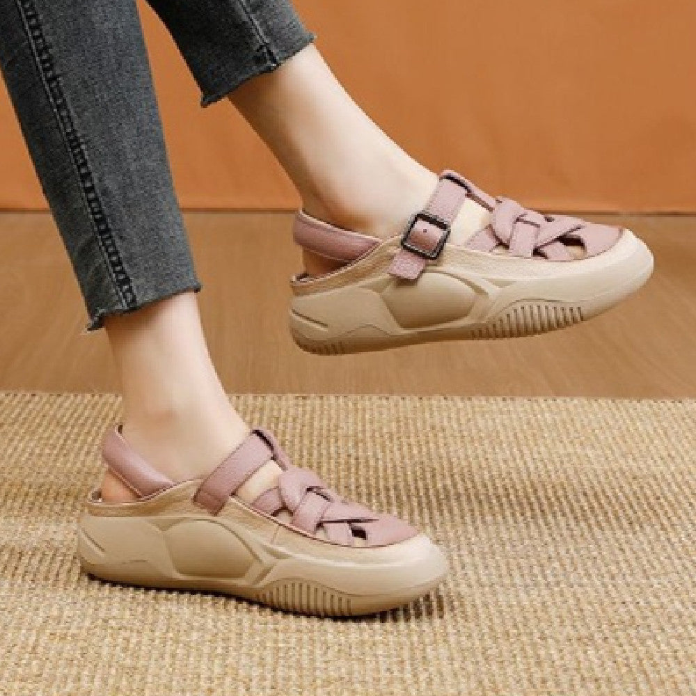 Beige and pink sandals worn with gray jeans on a woven surface.