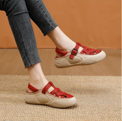 Red and beige sandals worn with gray jeans on a brown background