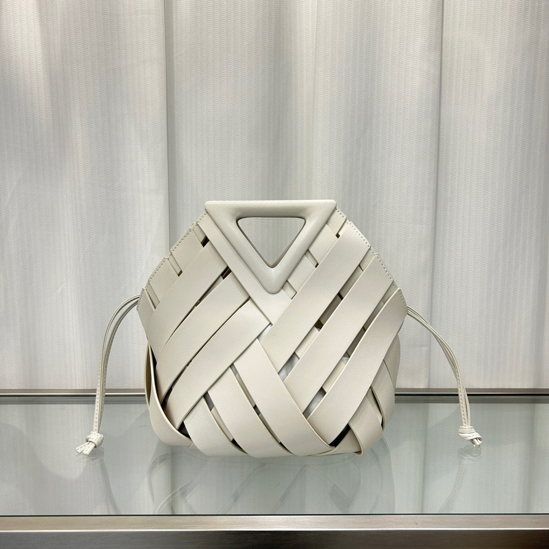 White  leather bag with a geometric design on a reflective surface