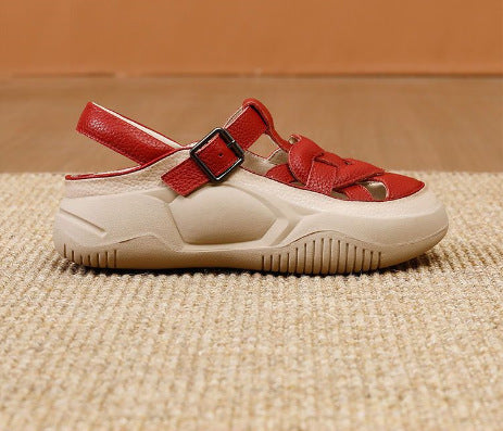 Red and white sandal with a strap on a textured surface