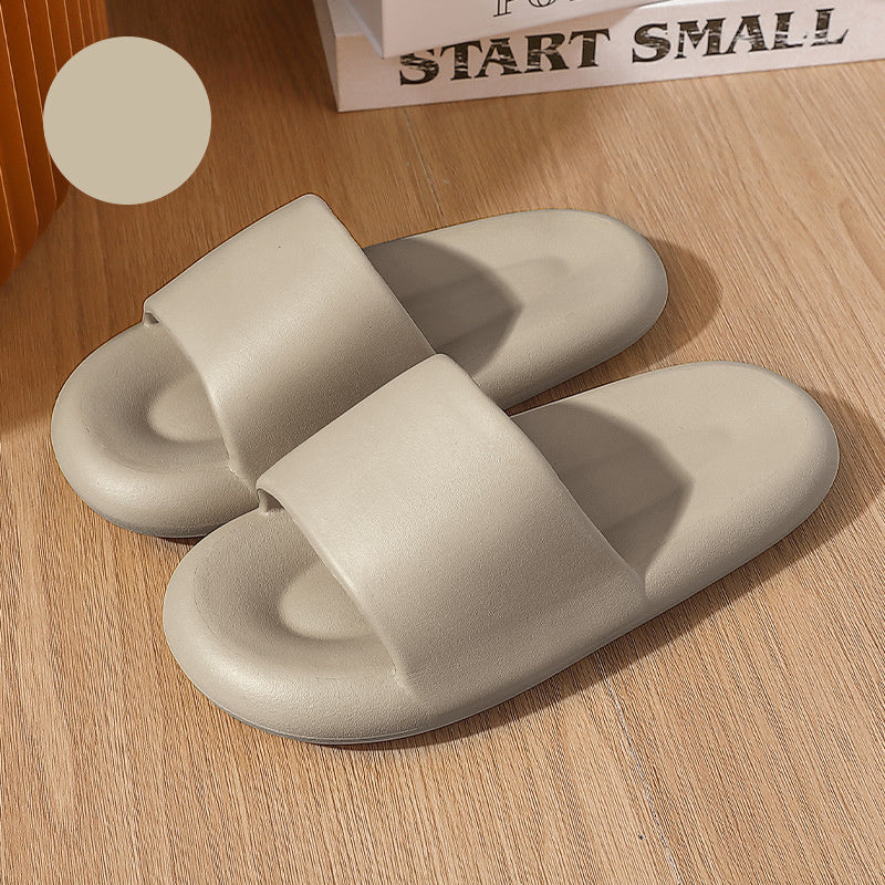 Pair of beige slippers on a wooden surface with a motivational quote in the background.