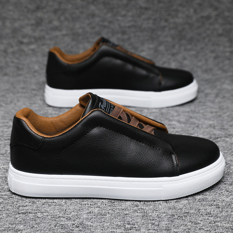Black leather shoes with brown accents on a gray background