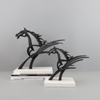 Black metal horse sculpture on a gray background
