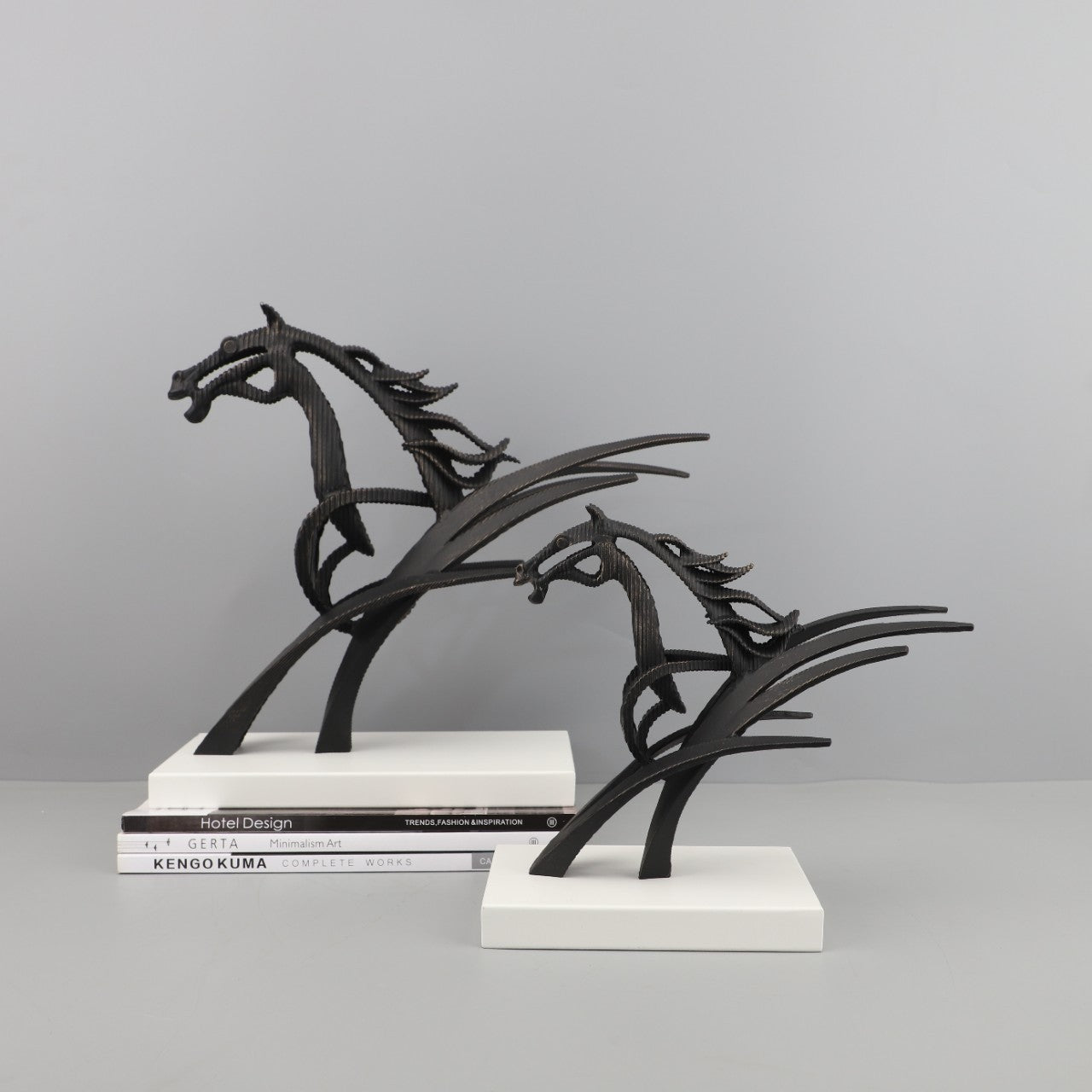 Black metal horse sculpture on a gray background