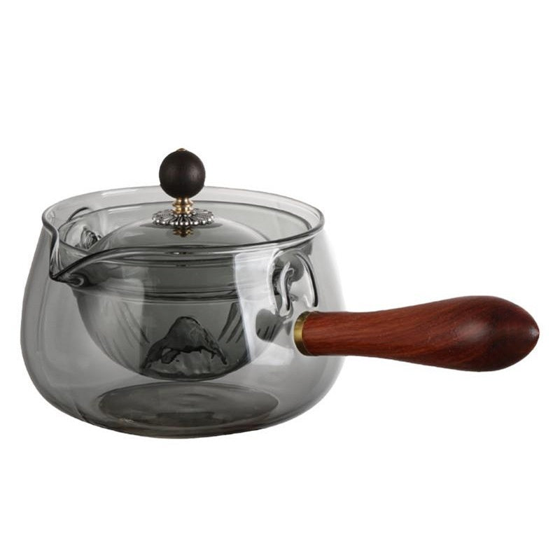 Glass teapot with wooden handle and lid knob on a white background