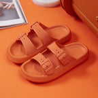Orange sandals with velcro straps on an orange surface