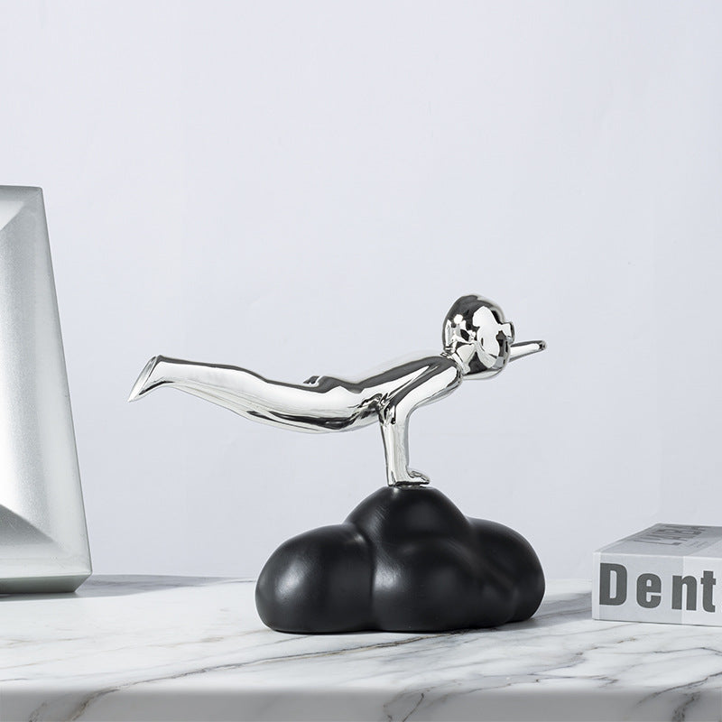 Decorative sculpture of a figure on a cloud with a laptop and box in the background