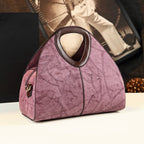 Pink textured handbag on a table with a blurred background