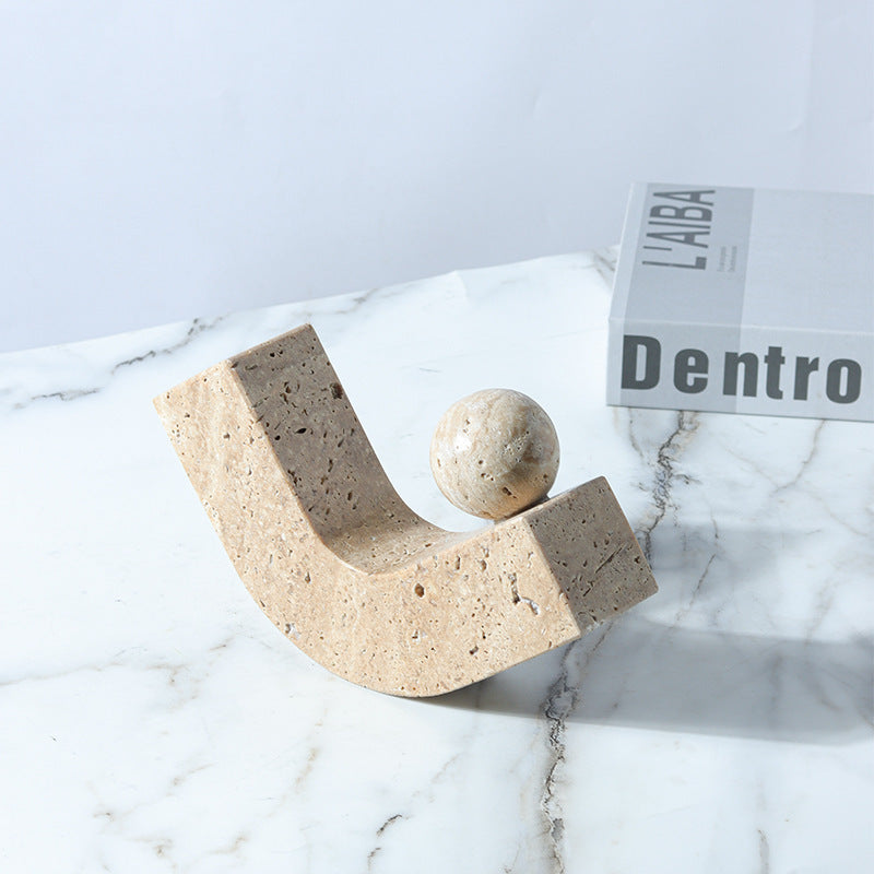 Decorative stone sculpture on a marble surface with a magazine in the background