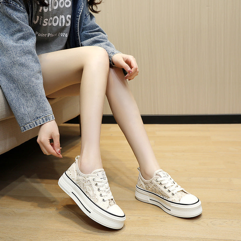 Person wearing white sneakers with a platform sole on a wooden floor.