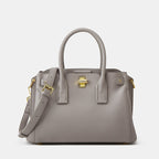 Gray handbag with gold accents on a light gray background