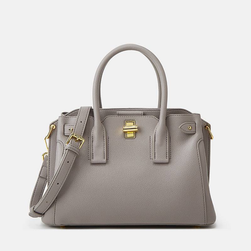 Gray handbag with gold accents on a light gray background