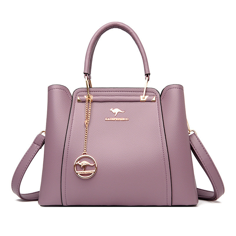 Purple handbag with a gold chain and emblem on a white background