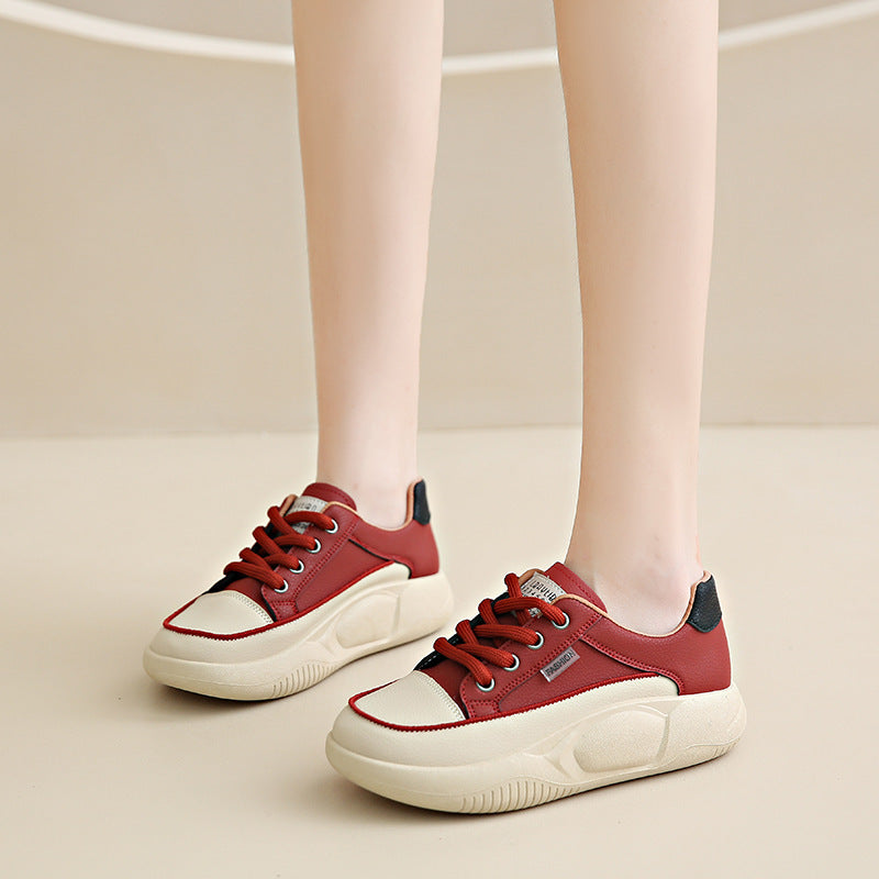 Red sneakers with white soles worn by a person on a beige background