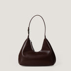 Brown leather handbag on a light beige background