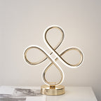 Decorative gold sculpture on a white surface with a neutral background