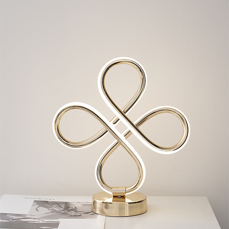 Decorative gold sculpture on a white surface with a neutral background