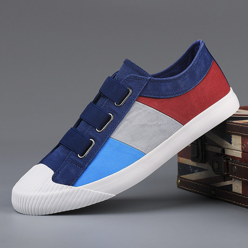 Multicolored sneaker with blue, red, and gray sections on a gray background