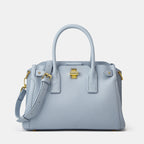 Light blue handbag with gold accents on a light gray background