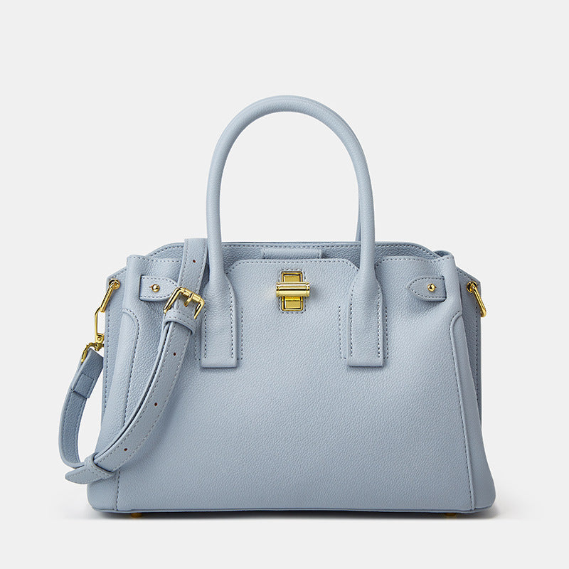 Light blue handbag with gold accents on a light gray background