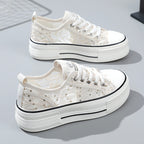 White sneakers with decorative elements on a light gray background
