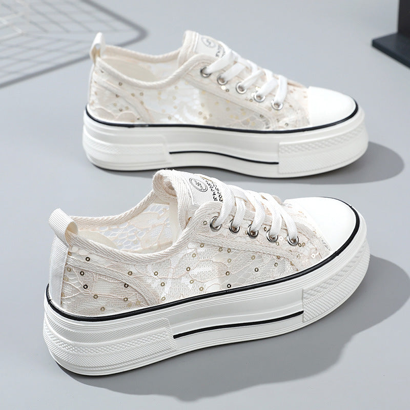 White sneakers with decorative elements on a light gray background