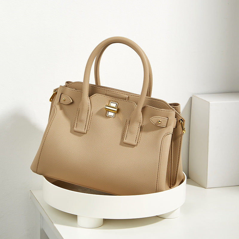 Beige handbag on a white stand with a white background