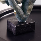Abstract sculpture on a black base against a dark background