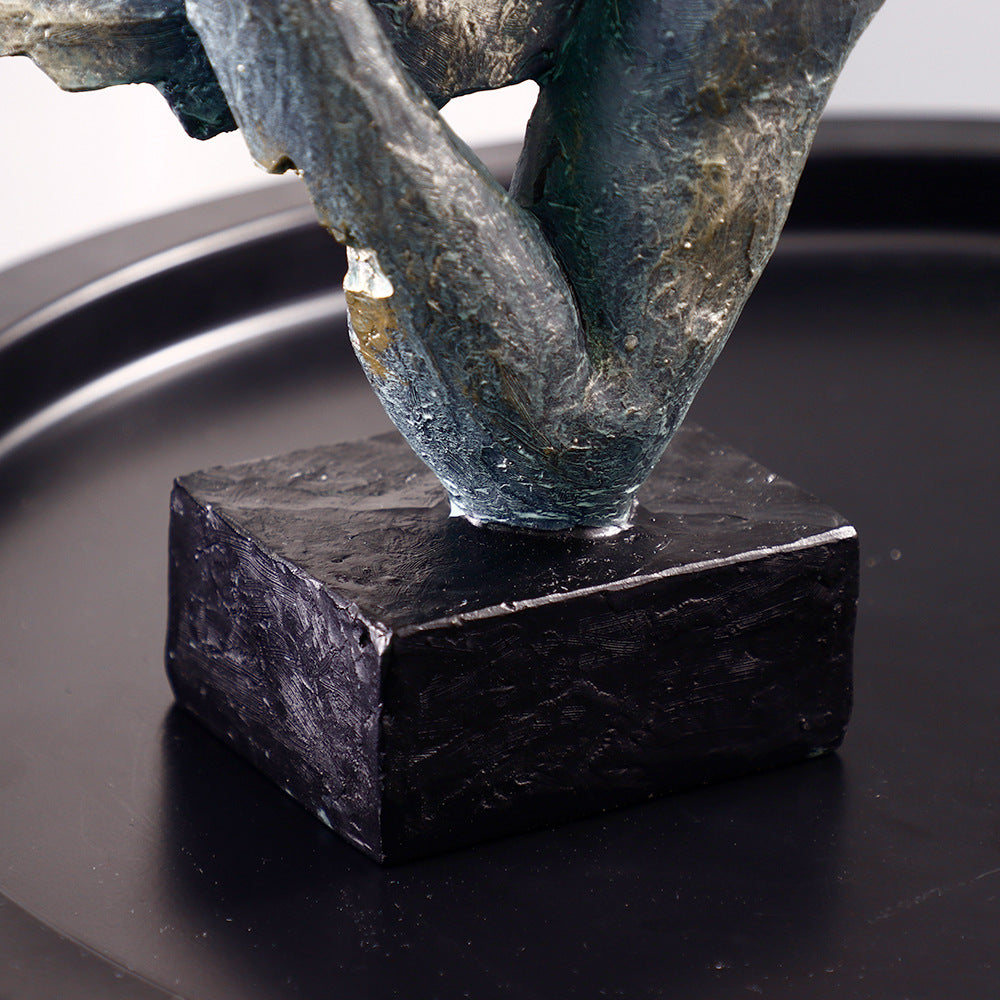 Abstract sculpture on a black base against a dark background