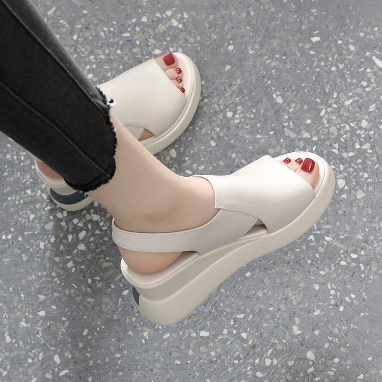 White sandals worn on a gray floor