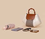 White handbag with brown accents on a beige background