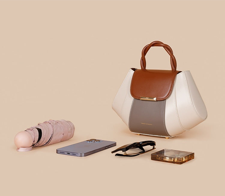 White handbag with brown accents on a beige background
