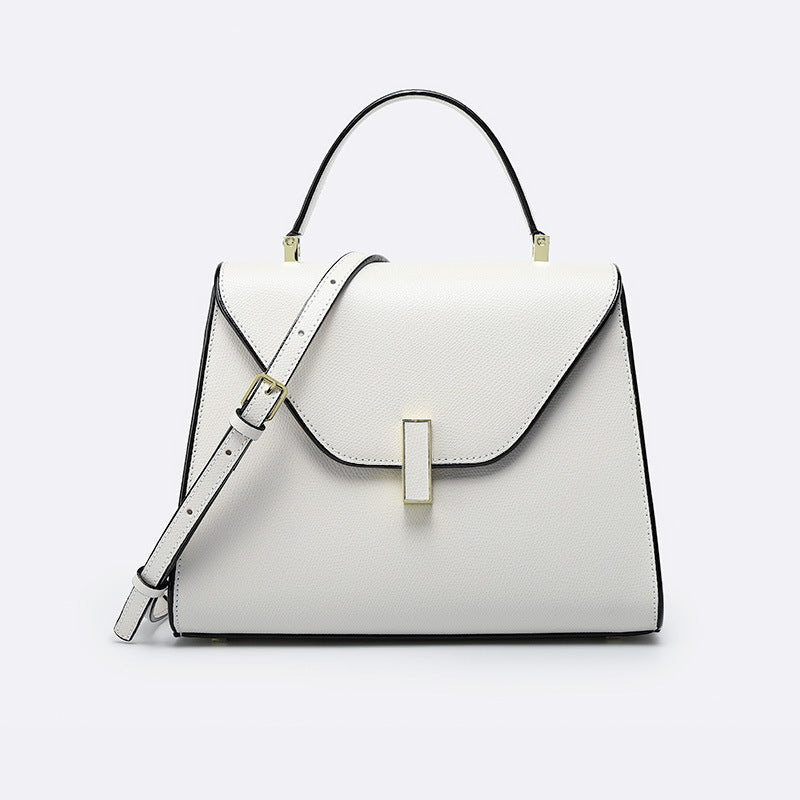White handbag with black accents on a light gray background