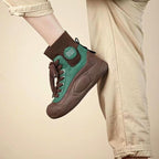 Brown and green sneaker worn by a person on a beige background
