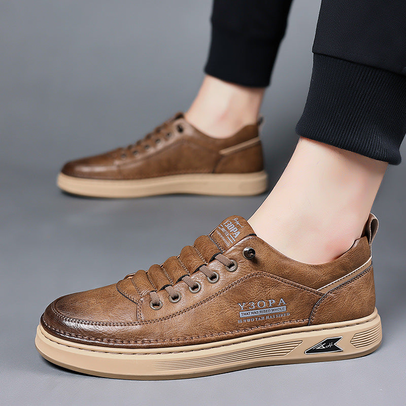 Brown leather sneakers worn by a person on a gray background