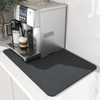 Espresso machine on a kitchen counter with a black mat underneath