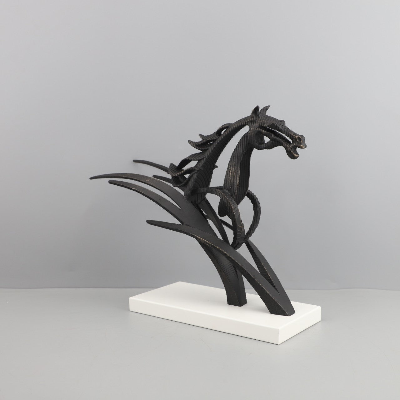 Black horse sculpture on a white base against a gray background