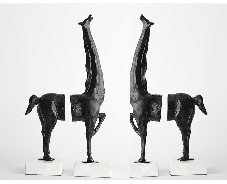 Set of four black abstract sculptures on white bases against a white background