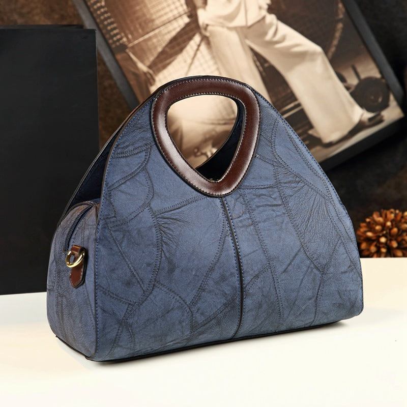 Blue textured handbag with brown accents on a white surface