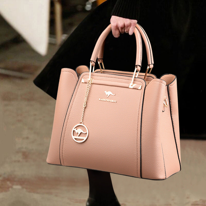 Pink handbag with a visible brand logo held by a person.