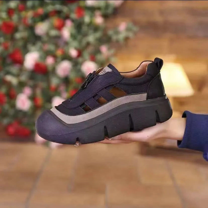 Person holding a black and gray sneaker with a blurred Christmas tree in the background