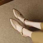 Beige loafers worn by a person on a textured surface