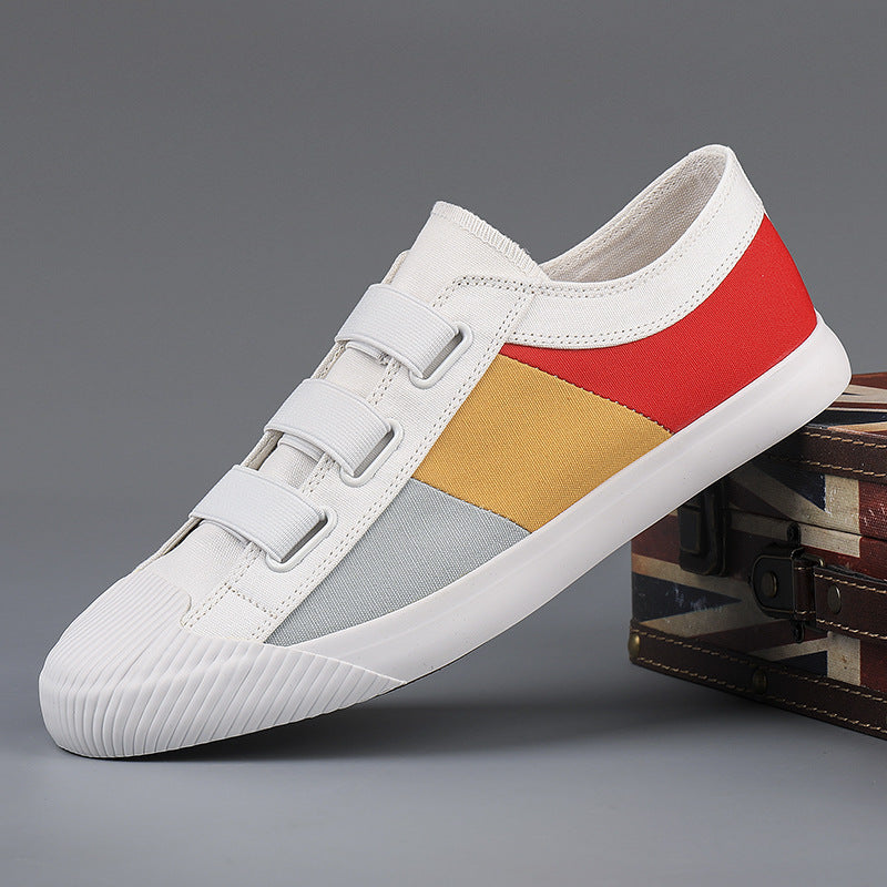 White sneaker with red, yellow, and gray accents on a gray background