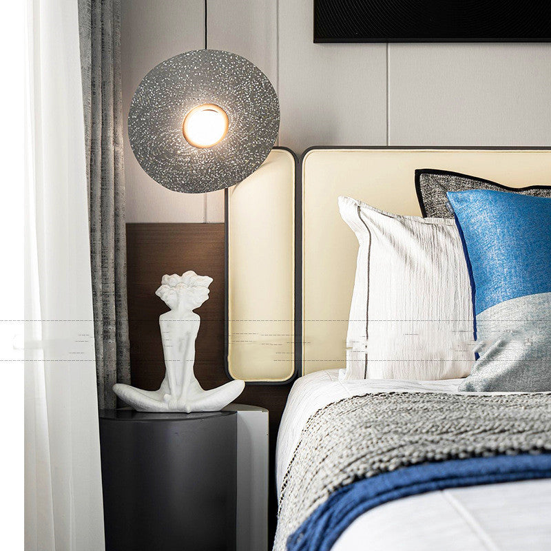 Modern bedroom with bed, nightstand, and decorative lamp.