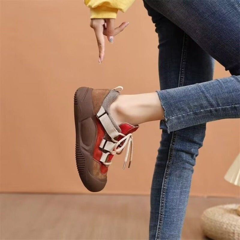 Person wearing a sandal with a brown sole and red and white straps on a beige background