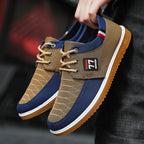 Brown and blue sneakers with a visible brand logo held by a person.