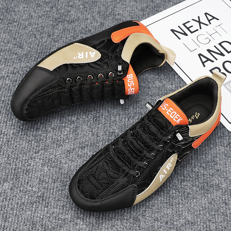 Black and orange sneakers on a gray surface with a newspaper in the background