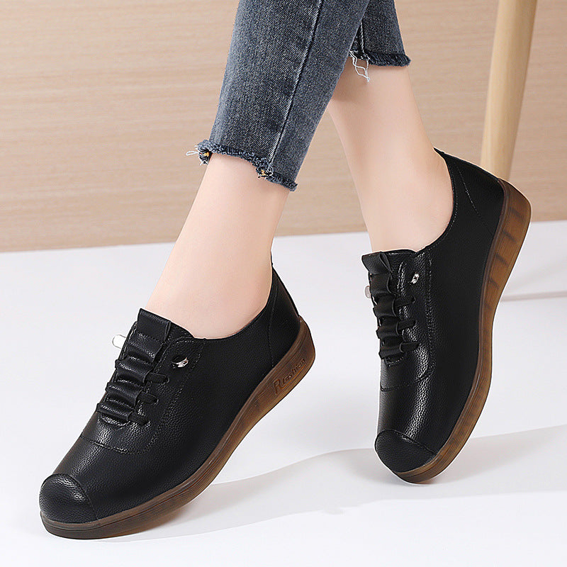 Black leather shoes with brown soles worn by a person on a white background